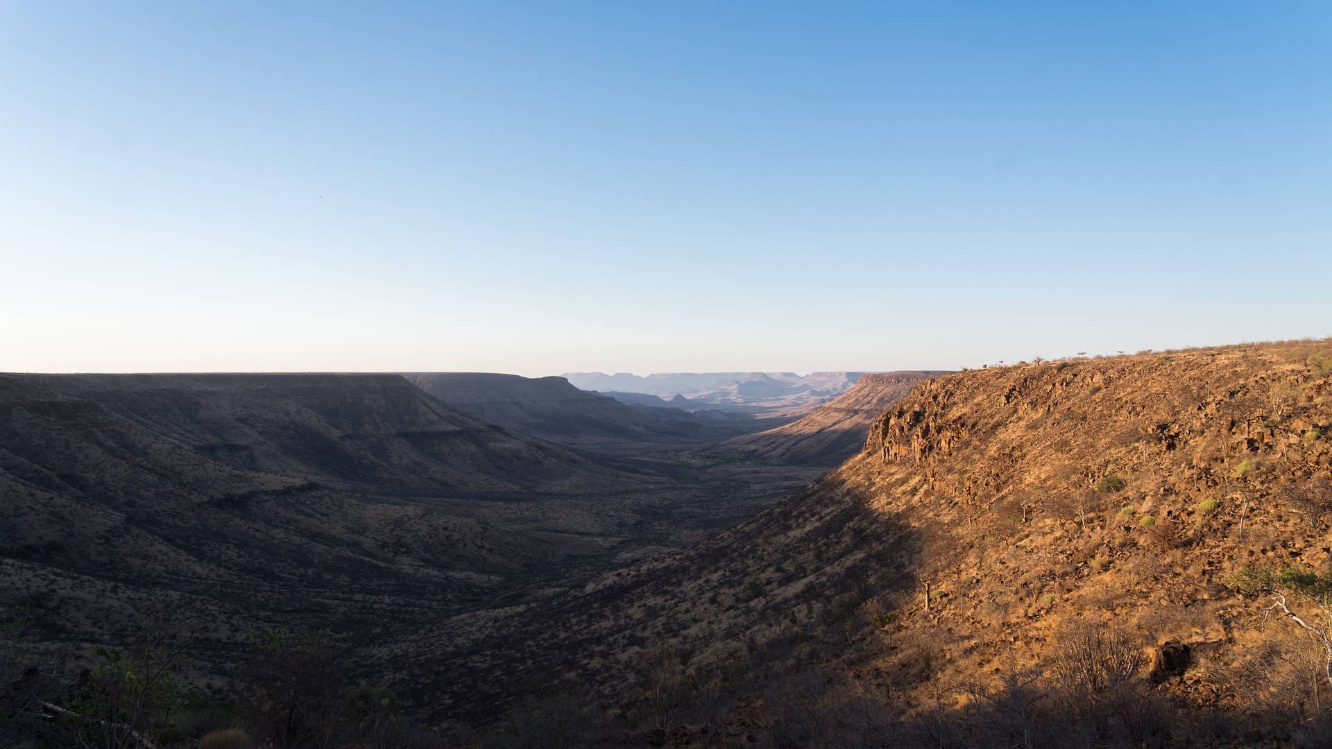 uitgestrekte rotsachtige vallei bij zonsopkomst in het ruige landschap van namibië