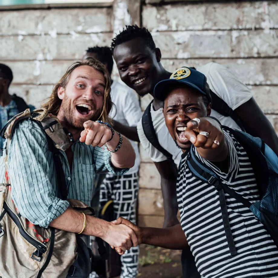 reiziger en lokale gids lachen en wijzen enthousiast naar de camera in kenia