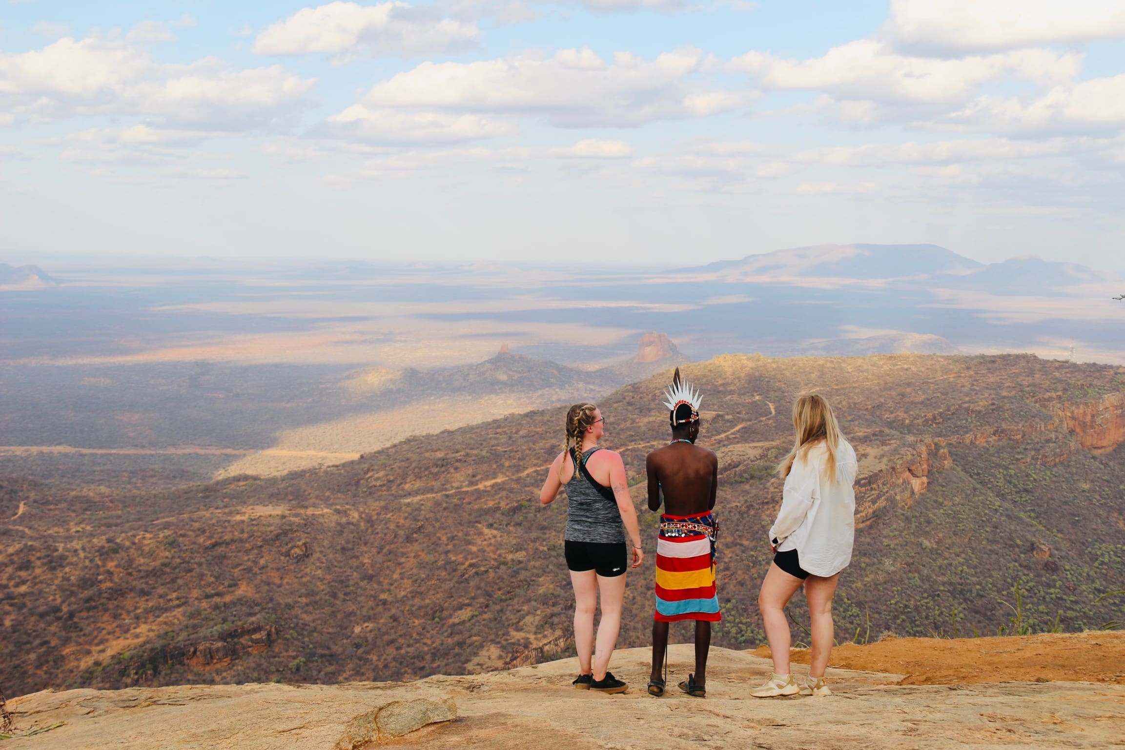 Masai gids wijst reizigers de weg vanaf een bergtop in Noord Kenia